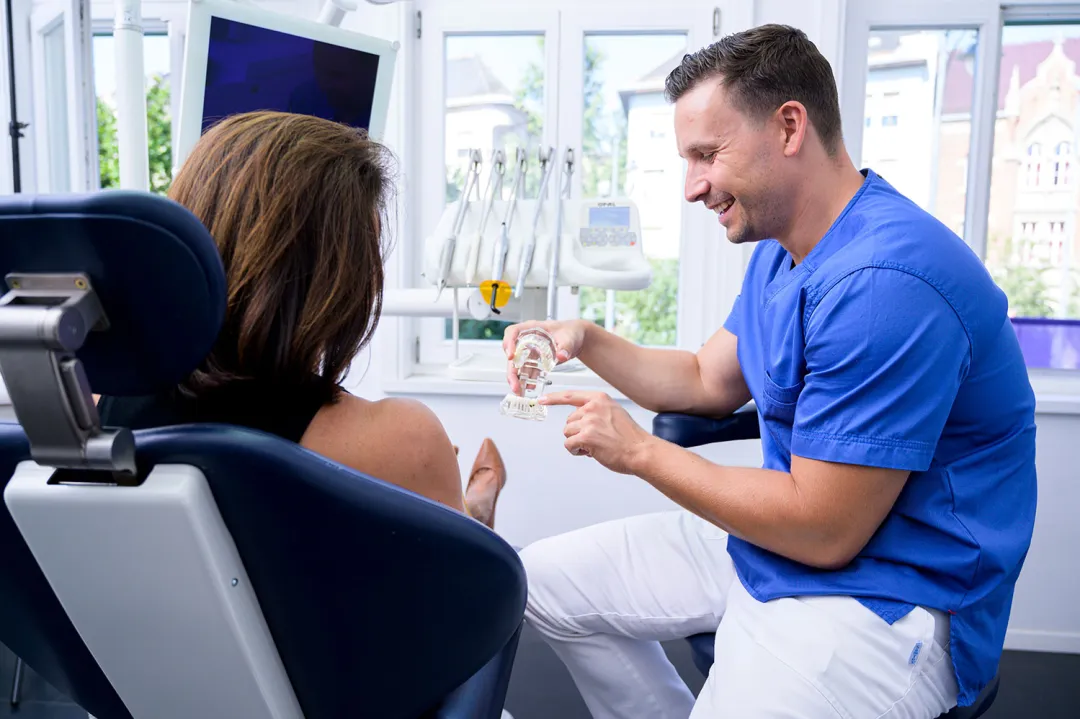 Doctor Andras explaining patient about dental implants